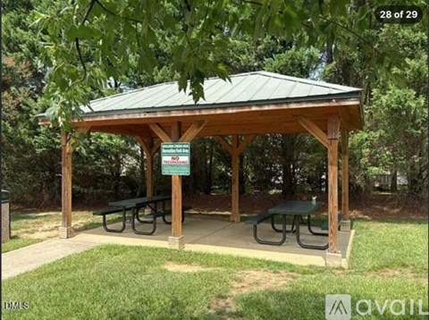 A pavilion with a green roof and a sign that says "NO PETS ALLOWED" is surrounded by trees.