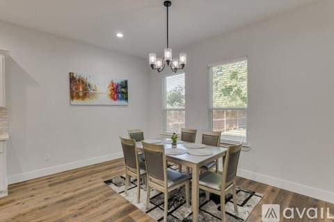 A dining room with a wooden table and chairs.