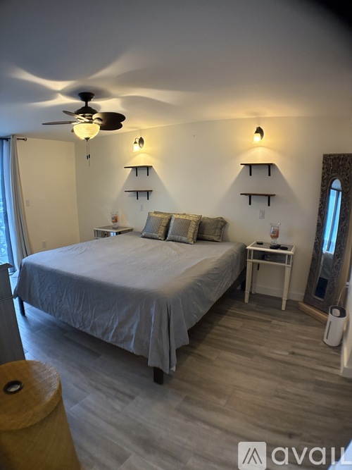 A bedroom with a bed, nightstand, and a ceiling fan.