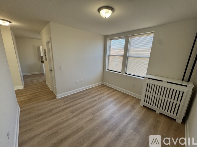 A room with a window and a radiator on the floor.