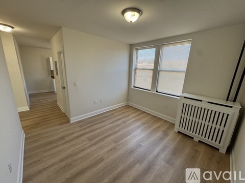 A room with a window and a radiator on the floor.