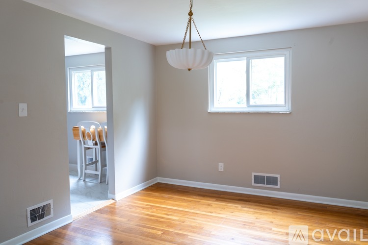 A room with a wooden floor and a hanging light fixture.