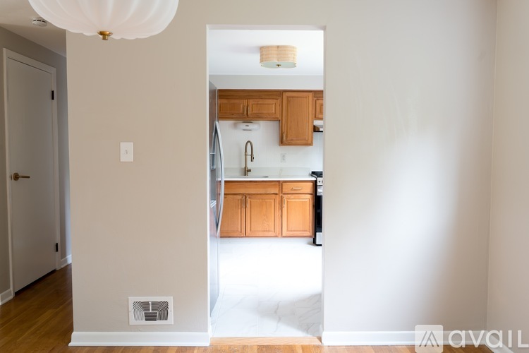 A kitchen with wooden cabinets and a white ceiling light.