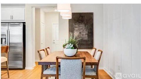 A dining room with a wooden table and chairs.