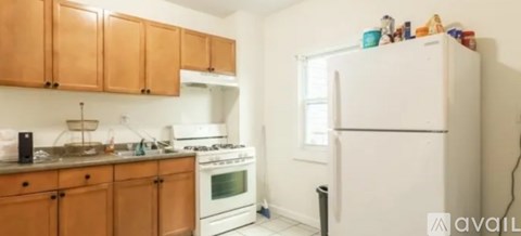 A kitchen with wooden cabinets and a white fridge.