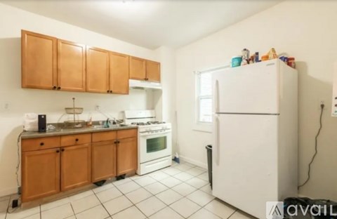 A kitchen with white appliances and wooden cabinets.