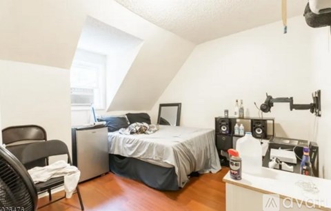 A bedroom with a bed, desk, and chair.