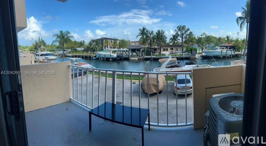 A balcony view of a marina with boats and palm trees.
