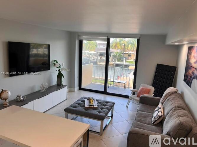 A living room with a couch, a coffee table, and a flat screen TV.