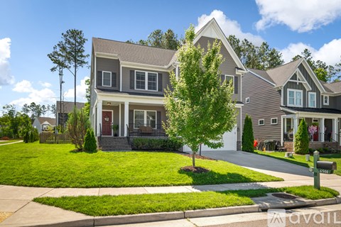 A house with a red door and a tree in front.