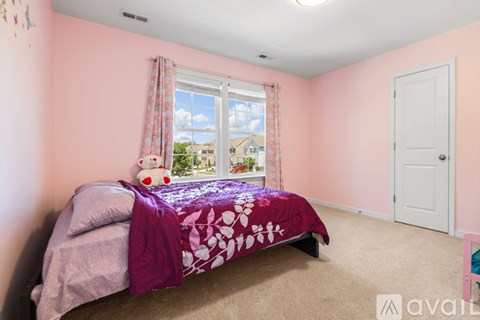 A bedroom with a bed and a window with curtains.