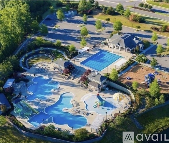 An aerial view of a water park with a large blue wave pool and a smaller wave pool with a slide.