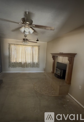 A living room with a fireplace and a ceiling fan.
