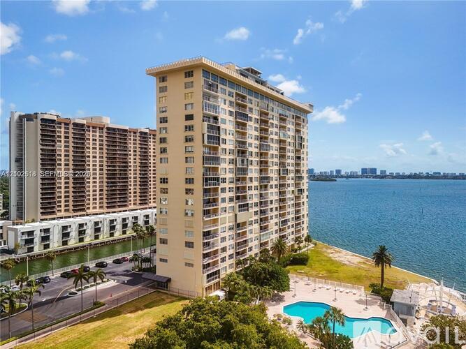 A tall building with a pool in front of it.