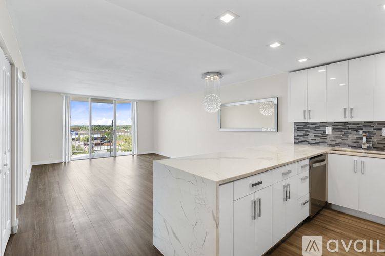 A modern kitchen with white cabinets and a large island.
