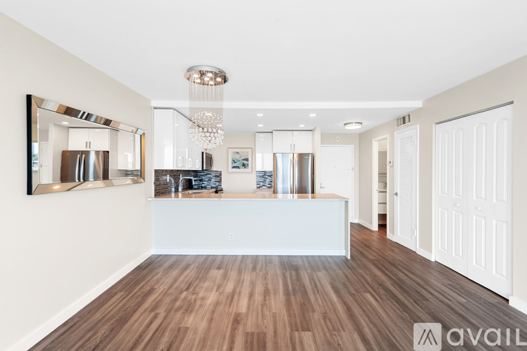 A modern kitchen with wooden floors and white walls.