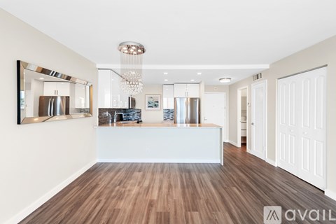 A modern kitchen with wooden floors and white walls.