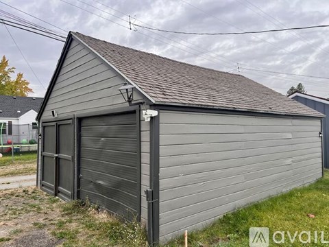 A grey building with a black door and a sign that says "available" in the foreground.