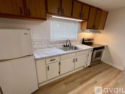 A kitchen with wooden cabinets and a white fridge.
