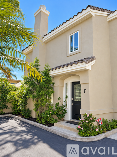 A house with a black door and a sign that says "avail" in front of it.