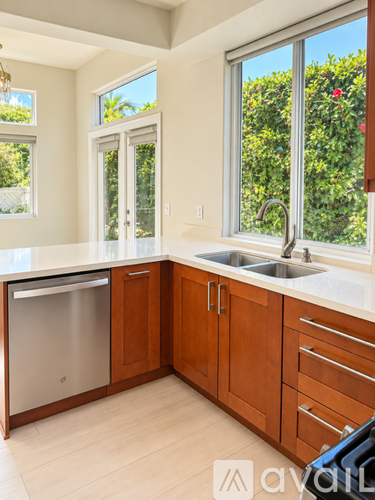 A kitchen with wooden cabinets and a stainless steel dishwasher.