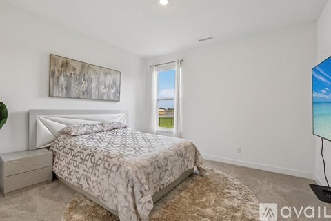 A bedroom with a large bed and a painting on the wall.