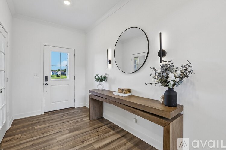 A white room with a wooden bench and a round mirror on the wall.
