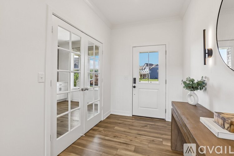 A white door with a glass window is open to a hallway.