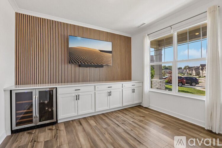 A room with wooden flooring and a painting of a desert landscape on the wall.