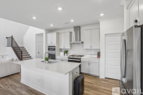 A modern kitchen with white cabinets and a central island.