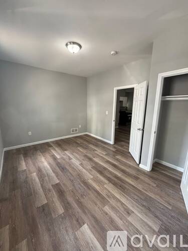 A room with wooden flooring and white walls.