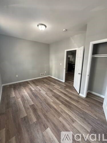 A room with wooden flooring and white walls.