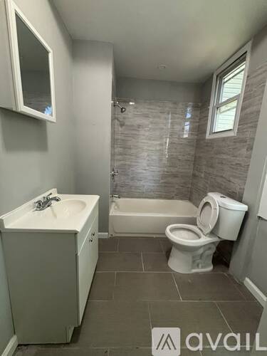 A bathroom with a toilet, sink, and bathtub.