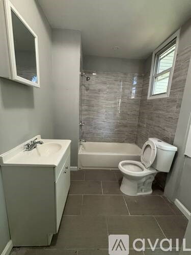 A bathroom with a toilet, sink, and bathtub.