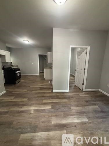 A room with wooden flooring and a white door.