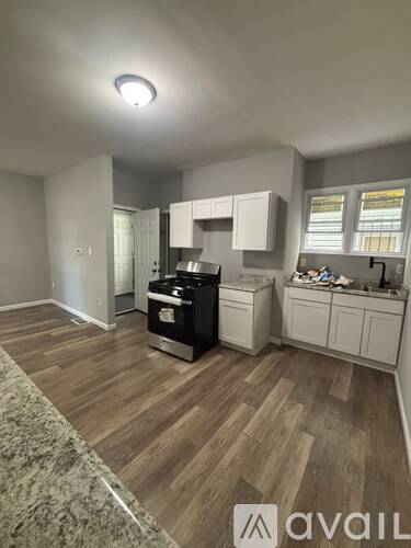 A kitchen with white cabinets and a black stove top oven.