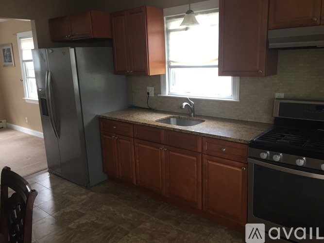 A kitchen with brown cabinets and a black stove top oven.