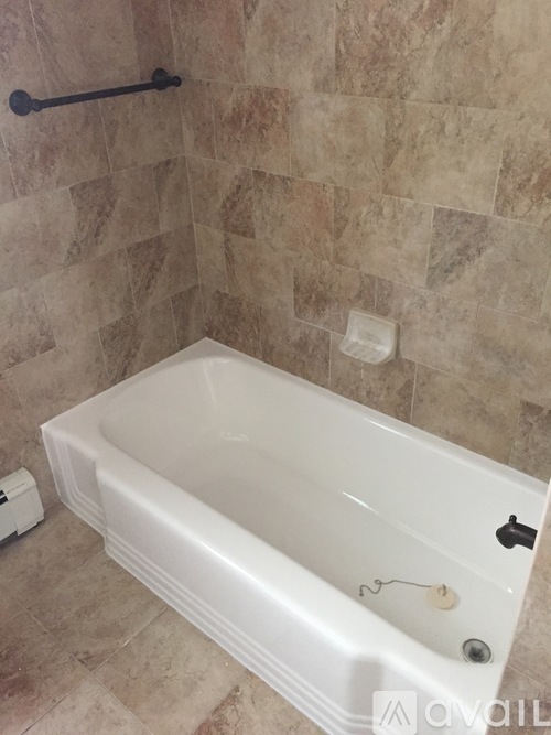 A white bathtub with a black faucet and a shower head.