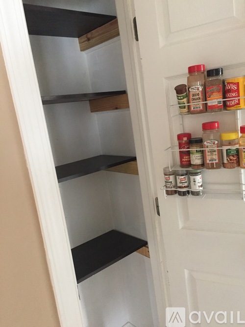A white door with a shelf of spices on the right side.
