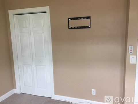 A white door is in a room with a beige wall.