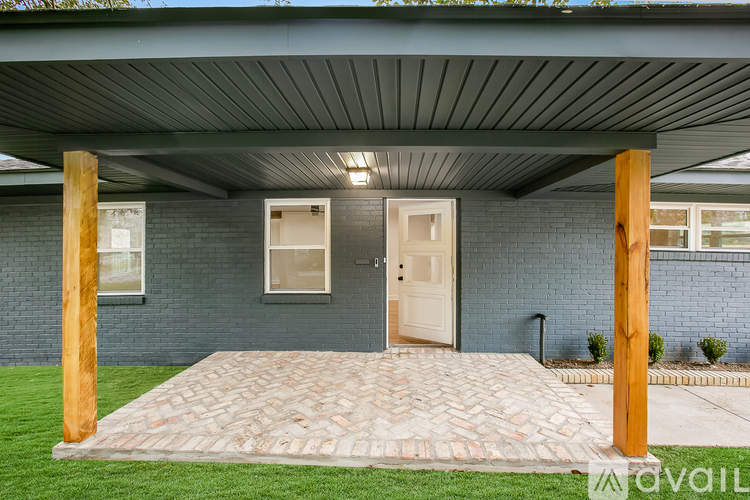 A house with a covered patio and a brick walkway.
