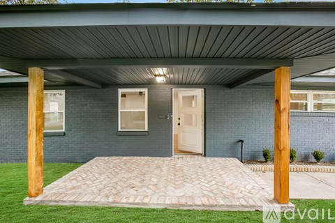 A house with a covered patio and a brick walkway.
