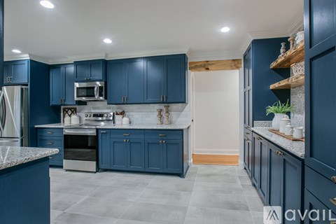 A kitchen with blue cabinets and a marble countertop.