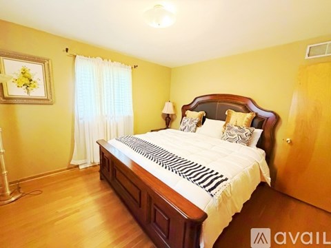 A bedroom with a large bed and a painting on the wall.