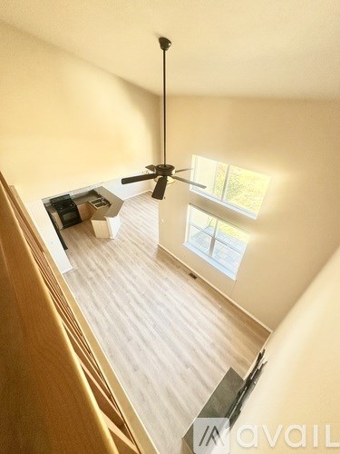 A room with a ceiling fan and a window letting in natural light.