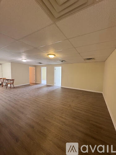 A room with wooden flooring and a table in the corner.