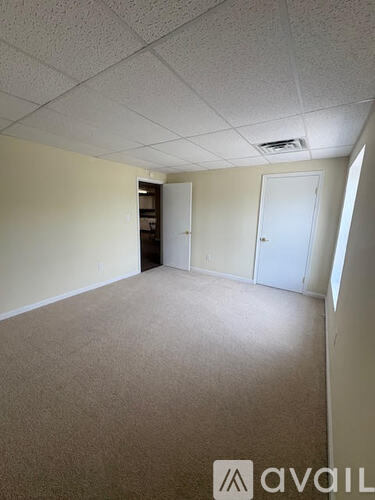A room with beige carpet and white walls.