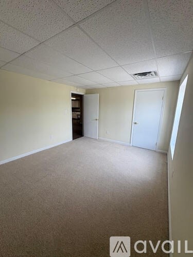 A room with beige carpet and white walls.