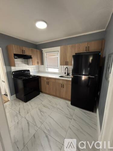 A kitchen with black appliances and wooden cabinets.