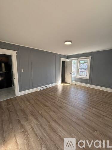 A room with wooden flooring and grey walls.